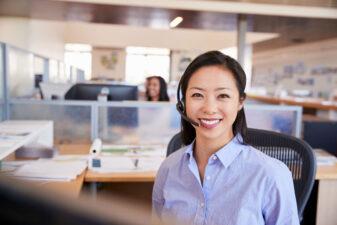 Young Asian Woman Working In A Call Centre Smiling To Camera